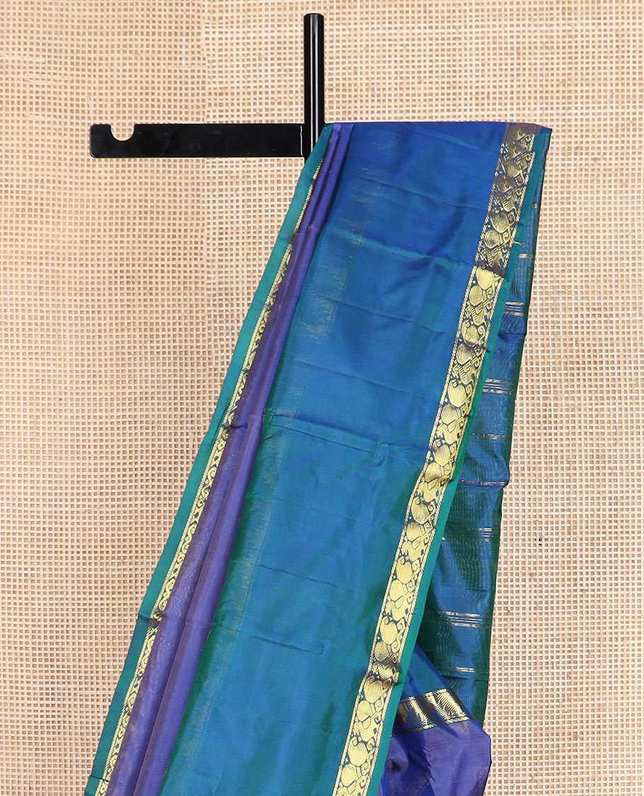 Blue plain Kanchipuram silk saree, contrast rettai pettu border of thazampoo rekku, manga, and mayil designs, and zari striped pallu