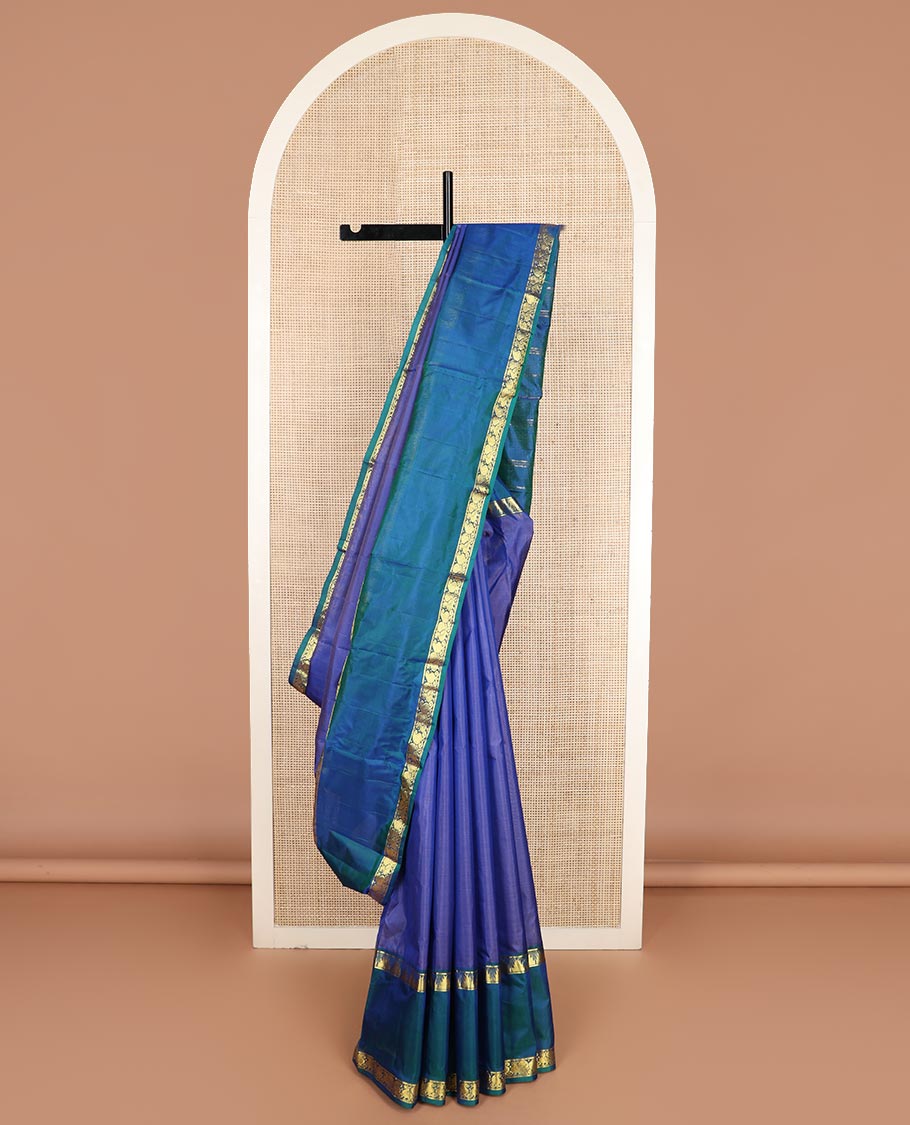 Blue plain Kanchipuram silk saree, contrast rettai pettu border of thazampoo rekku, manga, and mayil designs, and zari striped pallu
