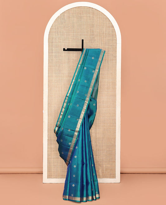 Blue Mayuri Soft Silk Saree, Highlighted with Rudraksham Buttas All Over Its Body, Subtle Border of Thazampoo Rekku, Muthu, and Kathir Designs, Sparsely Woven Jaal Pallu, and Paired with a Contrast Blouse