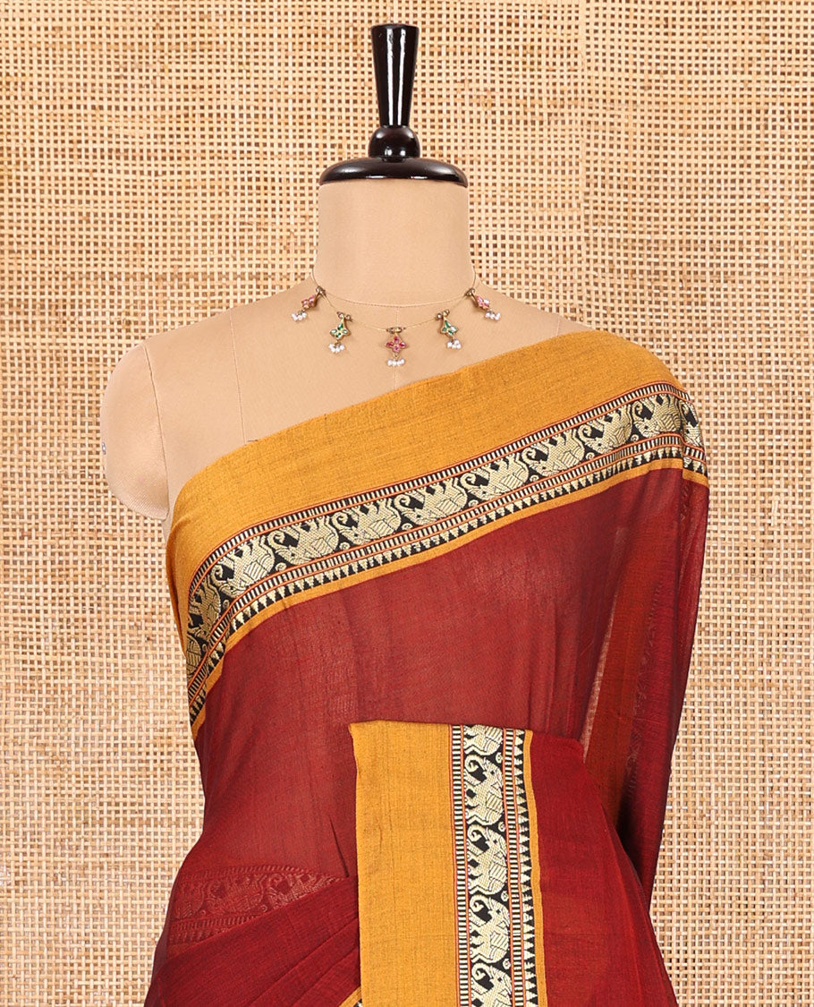 Maroon plain mercerised cotton saree, contrast kal erangina thread border of elephant motifs, striped pallu, and a matching blouse