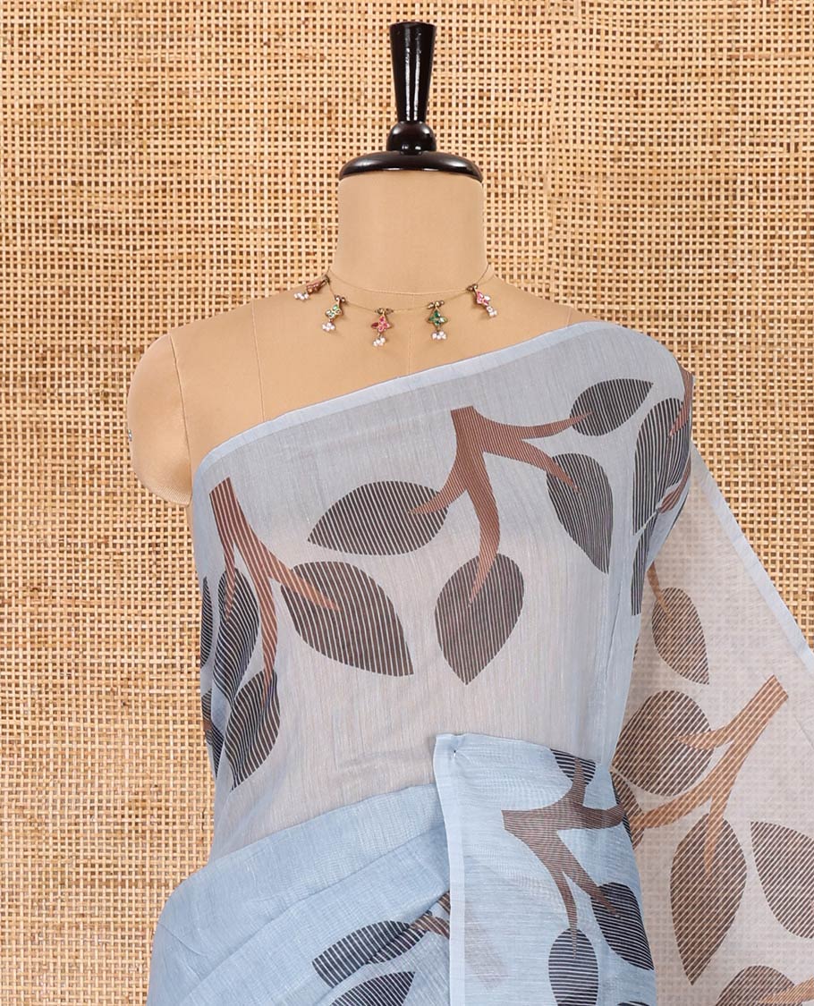 Grey plain linen cotton saree, branches and leaves printed border, printed pallu, and a contrast plain blouse