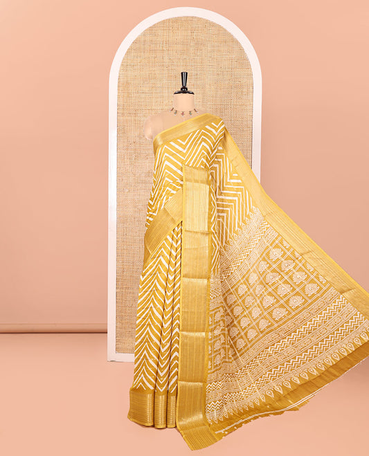 Yellow Moss Chiffon Saree Accentuated with Horizontal Stripes and Zig-Zag Stripes All Over Its Body, Highlighted by Traditional Zari Design Border, Pallu Depicts Butta Enclosed Checks, and Paired with a Matching Blouse