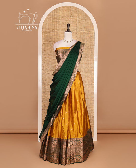Mustard taffeta silk half saree, zari buttas with contrast green traditional zari border, matching zari blouse, and contrast plain zari border dhavani