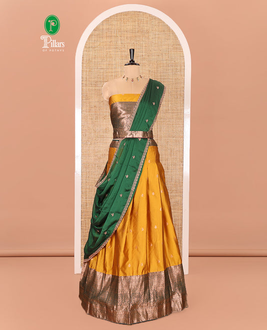 Yellow and Green Semi-Banarasi Half-Saree Beautified with Zari Buttas on Its Skirt, Complemented by a Contrast Traditional Zari Design Steeped Border, Paired with a Matching Blouse, and a Satin Georgette Embroidered Scallop Dhavani