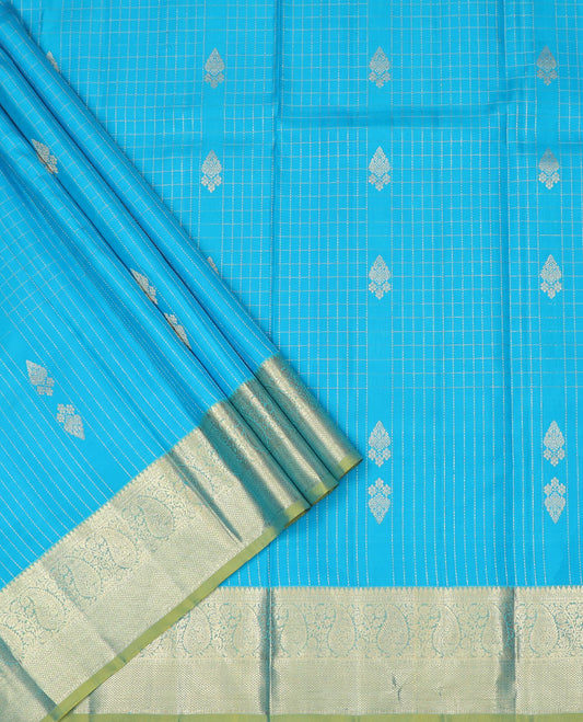 Blue Pure Silk Half-Saree Adorned with Zari Buttas Enclosed in Checks on the Skirt, Complemented by a Contrast Border Featuring Thilakam Mokku, Arumbu Manga, and Mayil Kann Designs, Paired with a Contrast Blouse, and a Jaal Design Dhavani