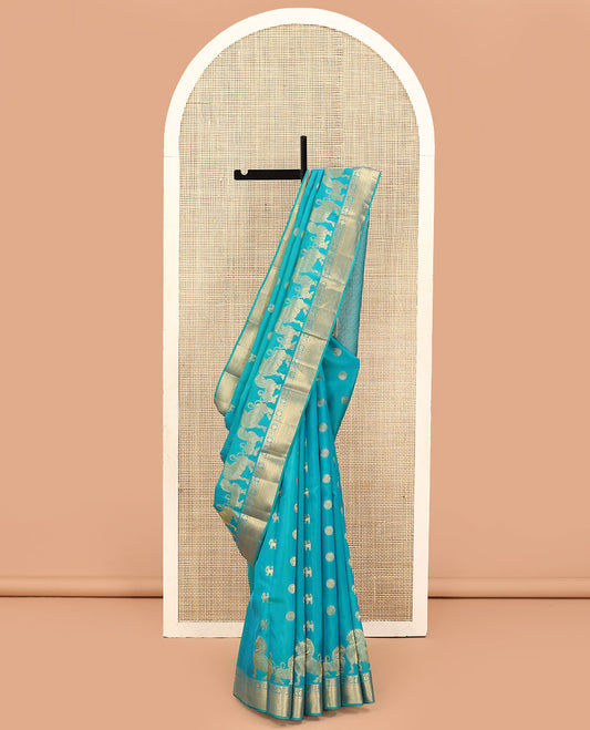 Blue Vasundhara Lite Silk Mix Saree, Gracefully Embellished with Yaali, Singam, and Chakram Buttas on Its Body, Highlighted by a Zari Border of Thilakam Mokku, Poun, Mayil, and Mayil Kann Designs, Subtle Jaal Pallu, and Paired with a Matching Blouse