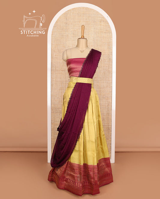Yellow art silk half-saree, brocade with contrast traditional border skirt, contrast maroon brocade blouse, scallop stone work dhavani, and detachable belt