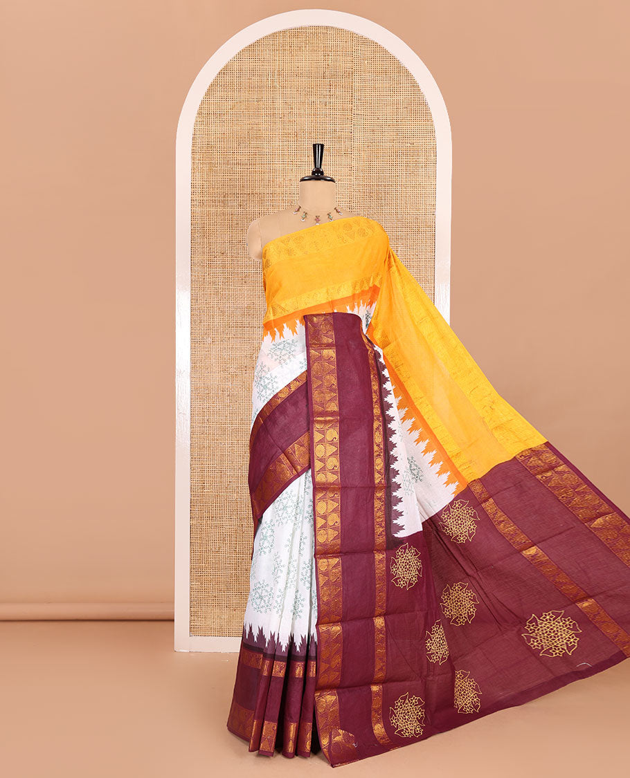 White kolam motifs printed Sungudi cotton saree, contrast yellow-maroon ganga jamuna rettai pettu traditional zari border, floral motifs pallu, and a contrast elephant motifs blouse