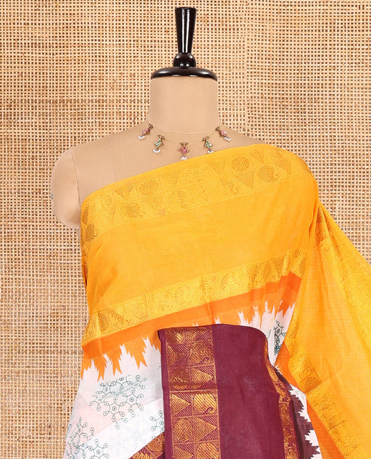 White kolam motifs printed Sungudi cotton saree, contrast yellow-maroon ganga jamuna rettai pettu traditional zari border, floral motifs pallu, and a contrast elephant motifs blouse