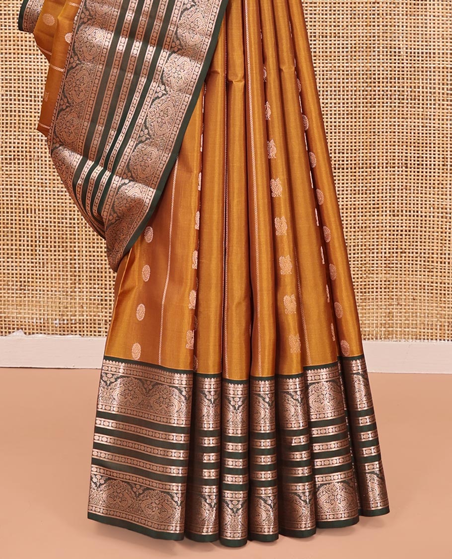 Mustard Vasundhara Lite Silk Mix Saree, Richly Detailed with Zari Buttas and Stripes All Over Its Body Complemented by Contrast Border of Thilakam Mokku, Rudraksham, and Mayil Designs, Grand Jaal Pallu, and Paired with a Contrast Blouse