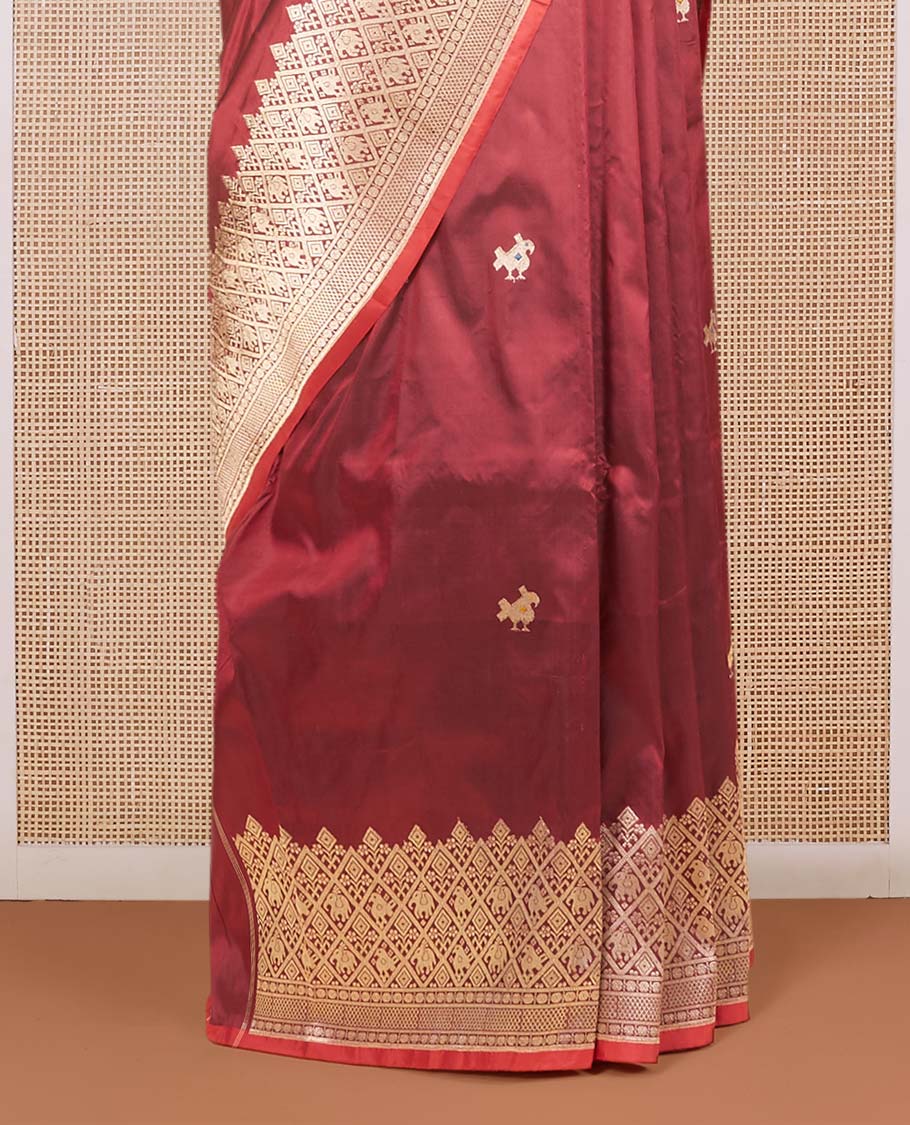 Maroon katan silk saree with patola-style zari buttas, zari border & pallu of patola-style animal motifs enclosed checks