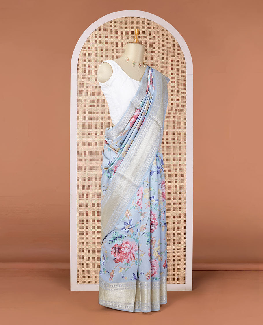Blue printed chiniya silk saree with colorful floral motifs, traditional zari design border