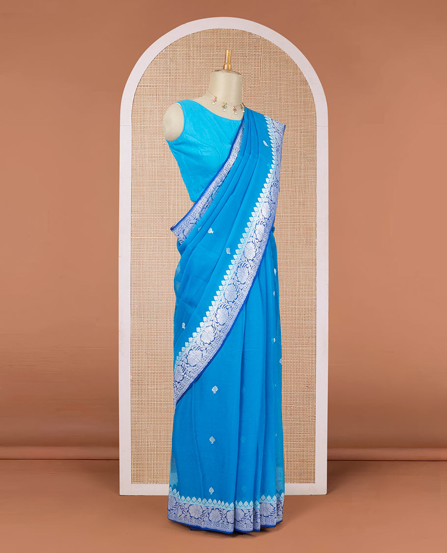 Light blue banarasi georgette saree with zari buttas, contrast floral creeper zari border & pallu of paisleys