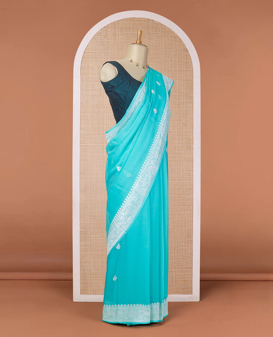Turquoise banarasi georgette saree with zari buttas, floral creeper zari border & pallu of paisleys