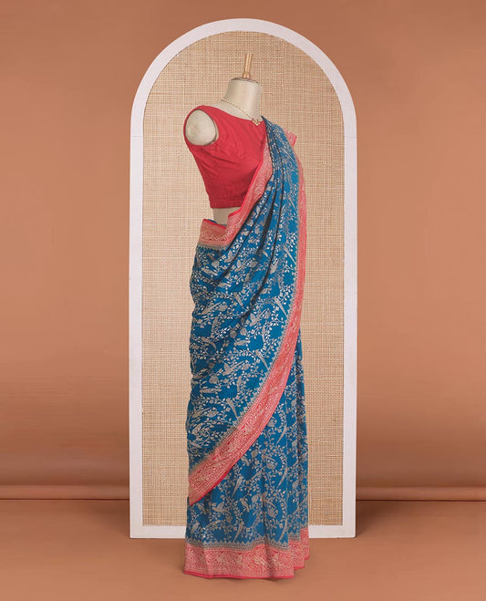 Blue floral and bird jaal jacquard banaras crepe saree, contrast floral and bird jaal zari border, and pallu of Mughal style motifs