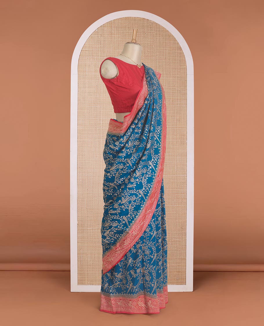 Blue floral and bird jaal jacquard banaras crepe saree, contrast floral and bird jaal zari border, and pallu of Mughal style motifs
