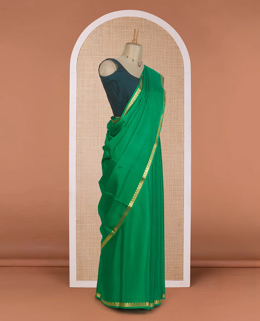 Green plain Mysore silk saree, zari border of paisleys, and zari striped pallu