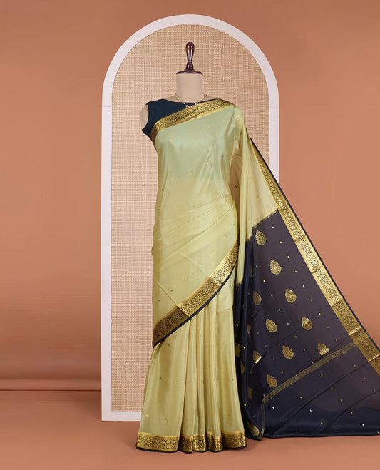 Pale green zari buttas Mysore silk saree, contrast floral vine design border, and thilakam motifs pallu