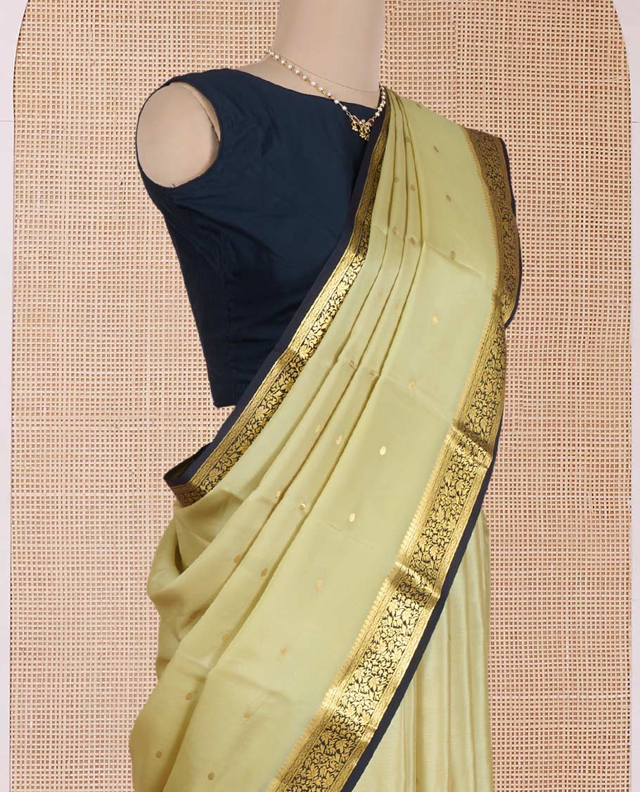 Pale green zari buttas Mysore silk saree, contrast floral vine design border, and thilakam motifs pallu