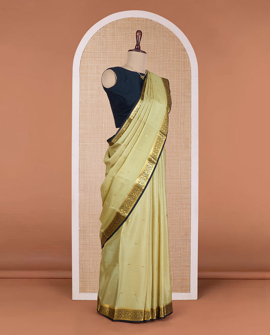 Pale green zari buttas Mysore silk saree, contrast floral vine design border, and thilakam motifs pallu