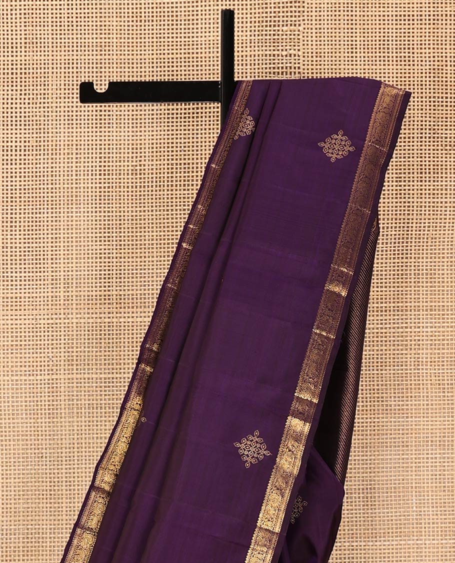 Purple Kanchipuram Silk Saree, Enriched with Kolam Buttas All Over Its Body, Highlighted by Zari Border of Rekku, Muthu, Mayil, Yaanai, and Rettai Neli Designs, Pallu Gleamed with Diagonal Stripes and Mayil Designs, and Paired with a Matching Blouse