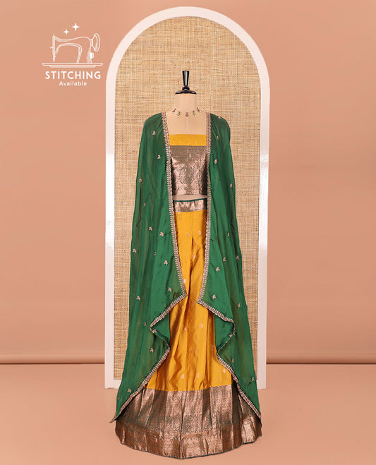 Yellow and Green Semi-Banarasi Half-Saree Beautified with Zari Buttas on Its Skirt, Complemented by a Contrast Traditional Zari Design Steeped Border, Paired with a Matching Blouse, and a Satin Georgette Embroidered Scallop Dhavani