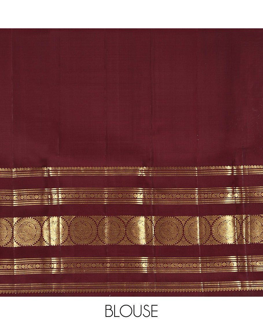 Maroon Kanchipuram Silk Saree, Crafted with Mayil and Chakram Buttas All Over Its Body, Highlighted by a Zari Border of Thilakam Mokku, Kathir, Kamalam, Manga, and Round Mayil Designs, Grand Jaal Pallu, and Paired with a Matching Blouse