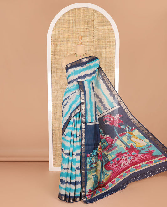 Blue shibori printed muslin cotton saree, contrast peacock zari border, village scenery printed pallu, and a contrast polka dotted zari border blouse