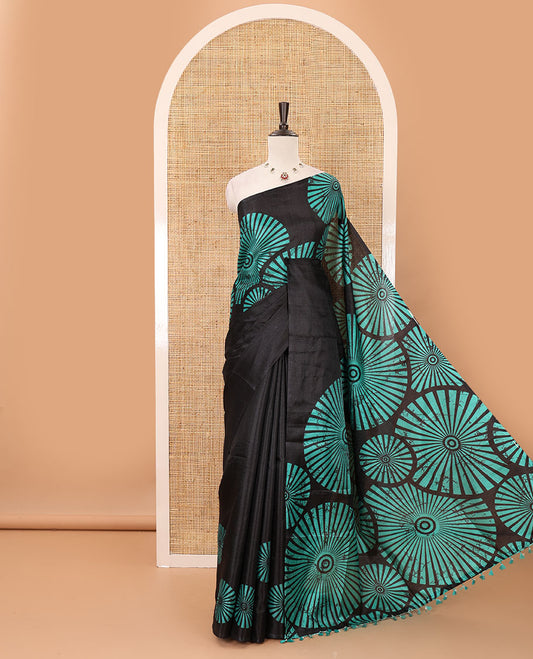 Black-base plain body khadi cotton saree with batik-style green-color radiant sunburst design on its border & pallu, plain black blouse