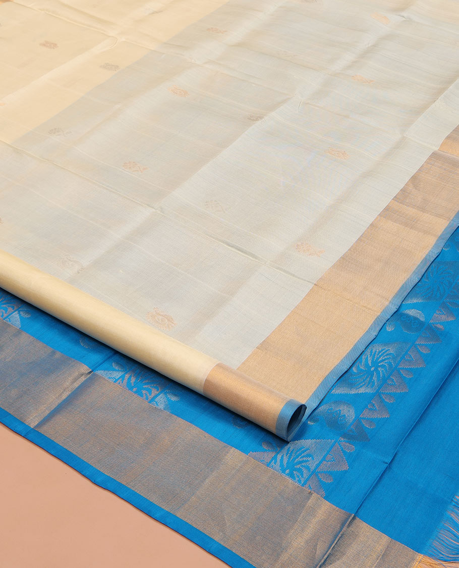 Cream Uppada Silk Saree, Subtly Sparkled with Zari Buttas All Over Its Body, Complemented by a Contrast Bavanji Border, Pallu Features Peacock Designs, and Paired with a Contrast Blouse
