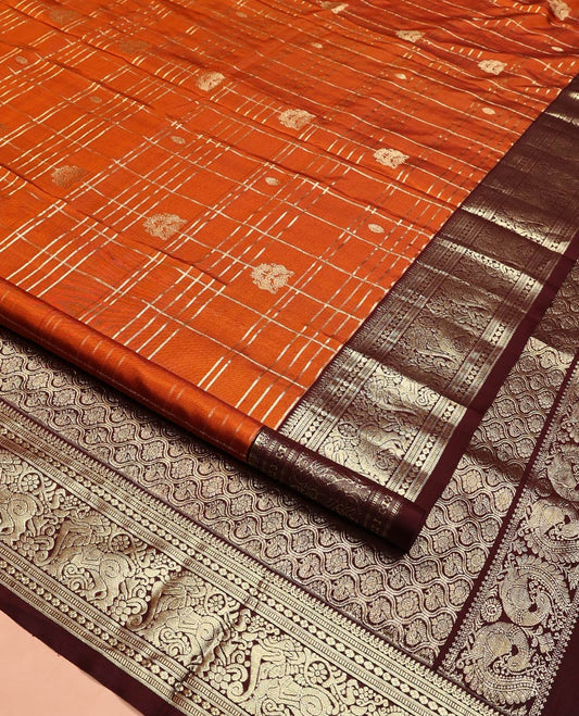 Orange Venkatagiri Silk Saree, Detailed with Zari Buttas Enclosed Checks All Over Its Body, Complemented by a Contrast Traditional Zari Border of Yaal Designs, Pallu of Ogee Designs, and Paired with a Contrast Blouse