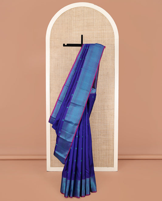 Blue Kanchipuram Silk Saree, Detailed with Mayil-Chakram Buttas All Over Its Body, Complemented by a Contrast Border of Thilakam, Banaras, Muthu, Rudraksham, Neli, and Vanki Designs, Pallu Steeped with Kamalam Designs, and Paired with a Contrast Blouse