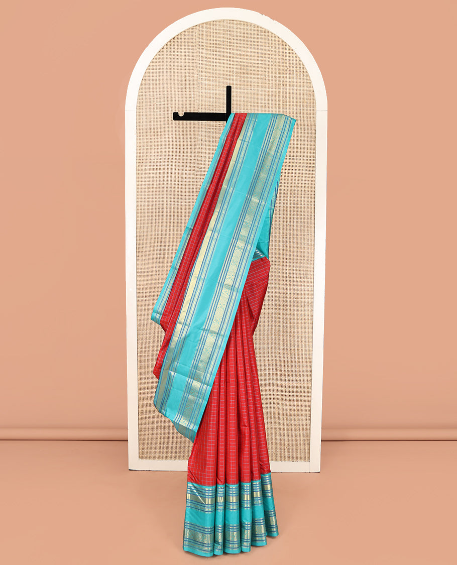 Tomato Red and Blue Vasundhara Silk Saree, Subtly Sparkled With Pattu Nool Kattam On Its Body, Complemented by Contrast Rettai Pettu Border of Salngai, Muthu, Neli, Rudraksham, and Dhavana Kodi Designs, Grand Pallu and Paired with a Contrast Blouse