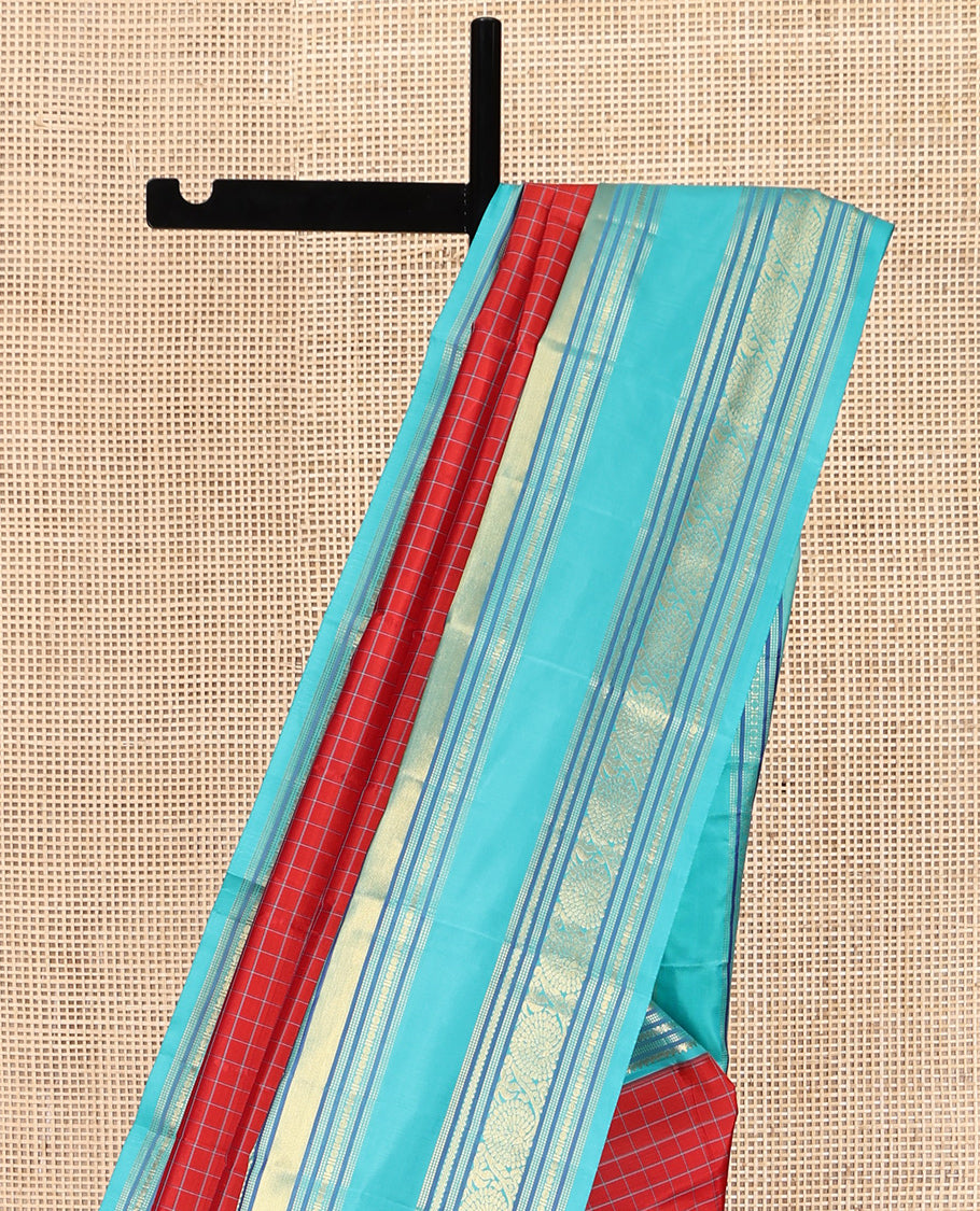 Tomato Red and Blue Vasundhara Silk Saree, Subtly Sparkled With Pattu Nool Kattam On Its Body, Complemented by Contrast Rettai Pettu Border of Salngai, Muthu, Neli, Rudraksham, and Dhavana Kodi Designs, Grand Pallu and Paired with a Contrast Blouse