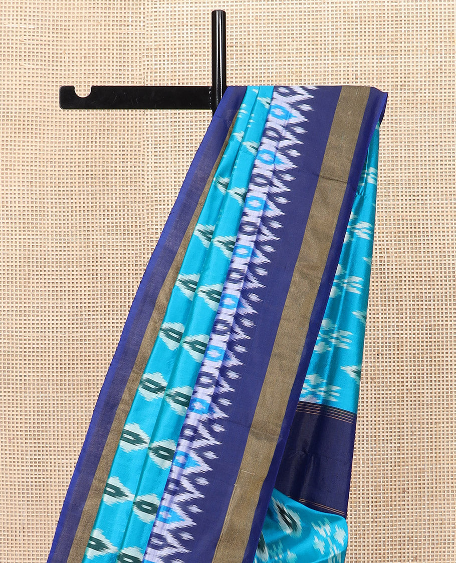 Blue Ikkat Silk Saree Decorated with Ikkat Buttas, Complemented by a Contrast Border, a Subtly Woven Pallu of Jaal Design, and a Contrast Plain Blouse