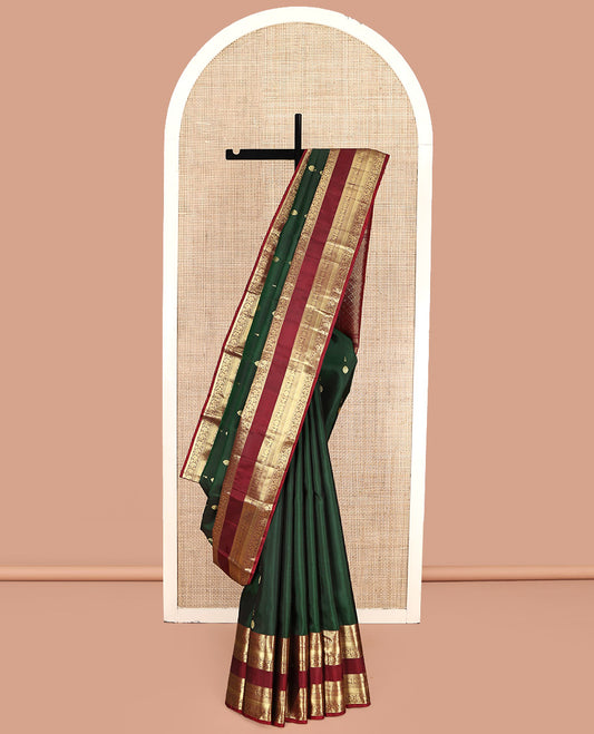 Green Kanchipuram Silk Saree, Woven with Zari Buttas All Over Its Body, Complemented by a Contrast Border of Rekku, Muthu, Kuthirai, Chakram, Mayil Kann, and Kodi Visiry Designs, Grand Jaal Pallu, and Paired with a Contrast Blouse