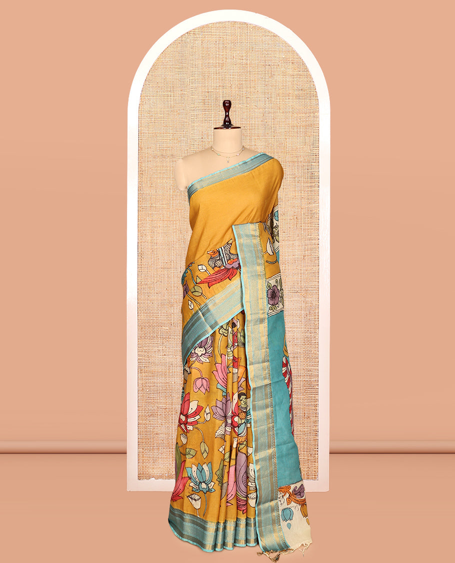 Gold Kalamkari Silk Saree, Impeccably Styled with Floral Vine and Human Motifs Print, a Contrast Traditional Zari Border, Pallu Features Peacocks, and a Contrast Blouse