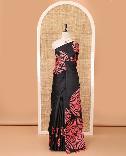 Black-base plain body khadi cotton saree with batik-style peach-color radiant sunburst design on its border & pallu, plain black blouse