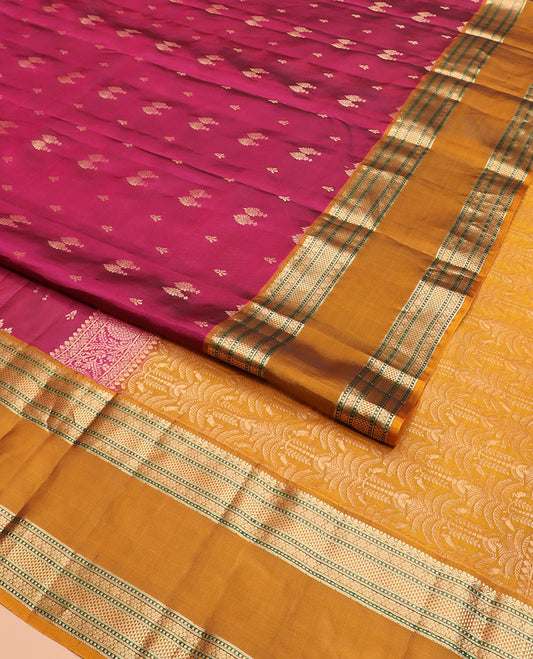Light Maroon Vasundhara Silk Saree Spotlighted with Zari Buttas, Complemented by a Contrast Rettai Pettu Border of Muthu, Ara Maadam, and Kamalam Designs, Grandly Woven Pallu of Intricate Designs, and a Contrast Blouse