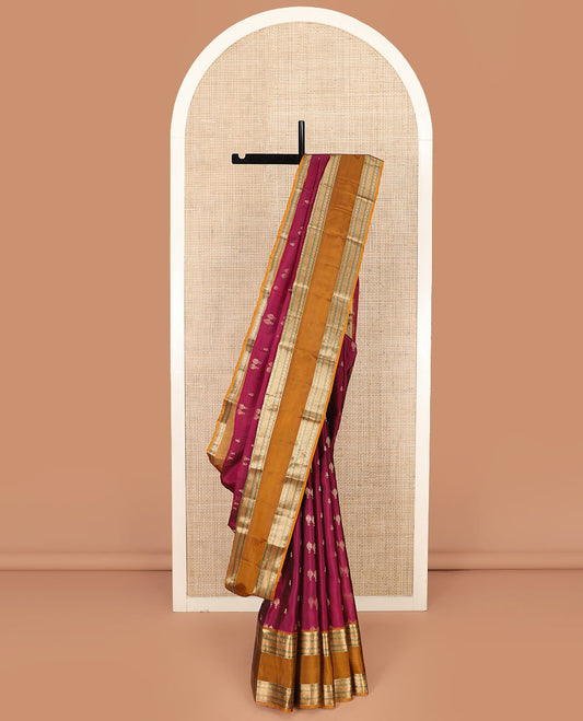 Light Maroon Vasundhara Silk Saree Spotlighted with Zari Buttas, Complemented by a Contrast Rettai Pettu Border of Muthu, Ara Maadam, and Kamalam Designs, Grandly Woven Pallu of Intricate Designs, and a Contrast Blouse