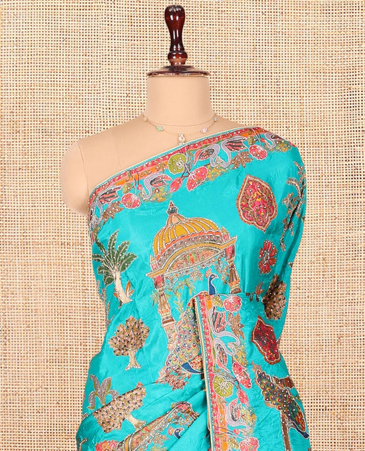 Blue Dola Silk Saree, Featuring Colorful Flora, Fauna, and Mughal-Style Print on Its Body, Highlighted by Kaleidoscopic-Colored Floral-Bird Embroidered Border, Pallu Mirroring the Same Design, and Paired with a Contrast Blouse