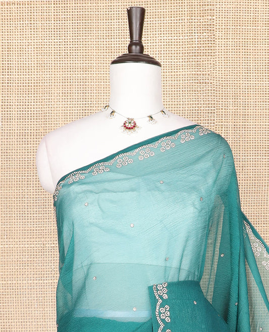 Green stone embroidered designer saree with stones embedded in its body, flower-shaped stone aligned scallop border