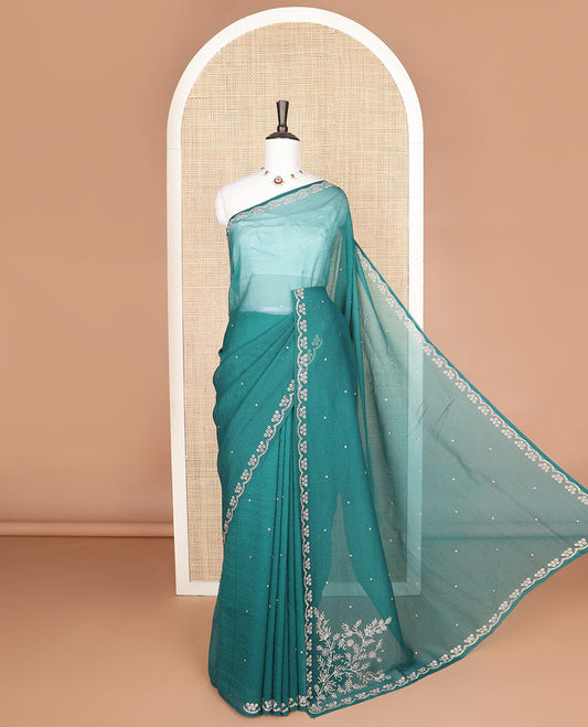 Green stone embroidered designer saree with stones embedded in its body, flower-shaped stone aligned scallop border