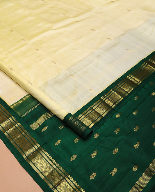 Pale Yellow Kanchipuram Silk Saree, Subtly Sparkled with Zari Buttas All Over Its Body, Complemented by a Contrast One-Sided Korvai Border of Thilakam Mokku, Banaras, and Jaal Designs, Pallu of Zari Designs, and Comes Without a Blouse