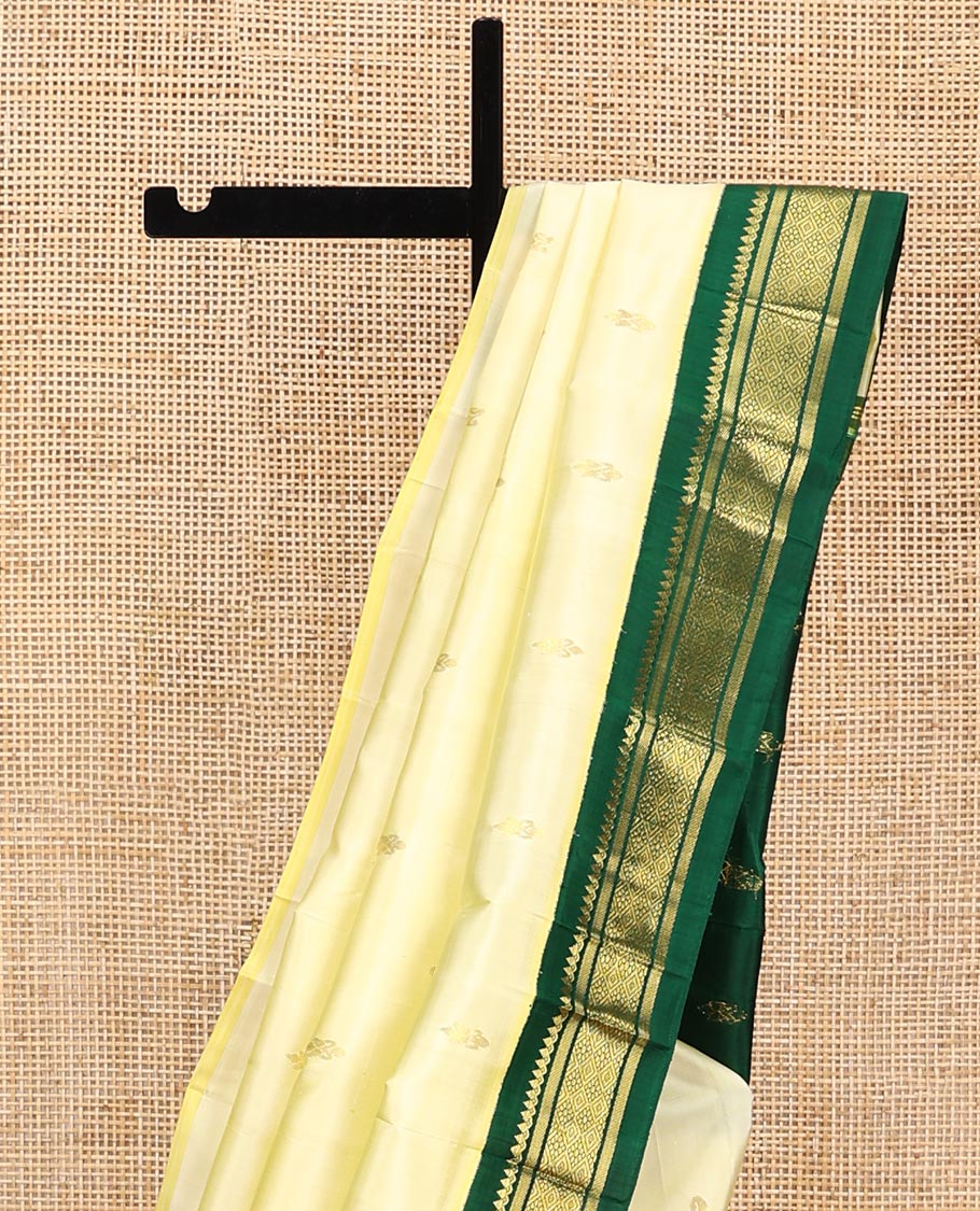 Pale Yellow Kanchipuram Silk Saree, Subtly Sparkled with Zari Buttas All Over Its Body, Complemented by a Contrast One-Sided Korvai Border of Thilakam Mokku, Banaras, and Jaal Designs, Pallu of Zari Designs, and Comes Without a Blouse