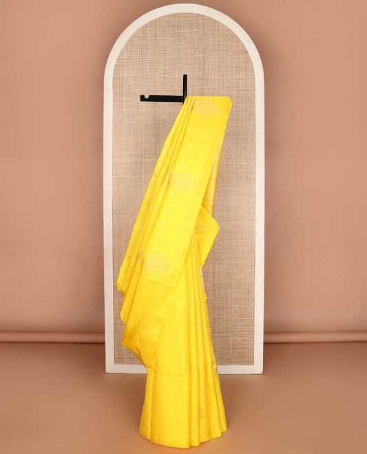 Borderless yellow soft silk saree with zari buttas, self-pallu adorned with intricate zari designs