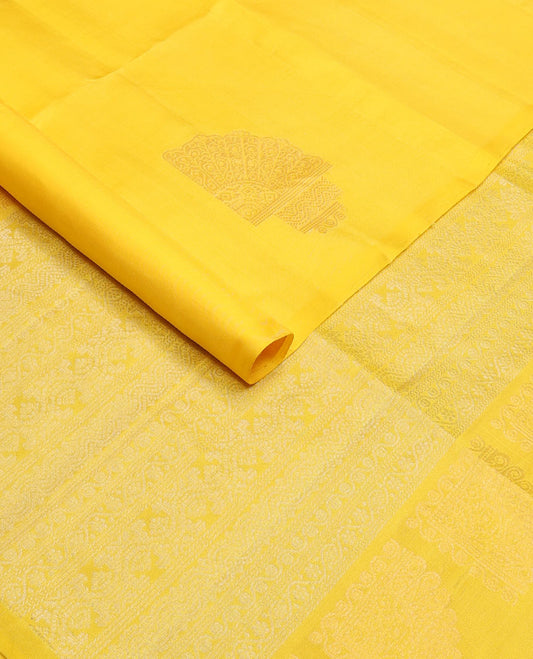 Borderless yellow soft silk saree with zari buttas, self-pallu adorned with intricate zari designs