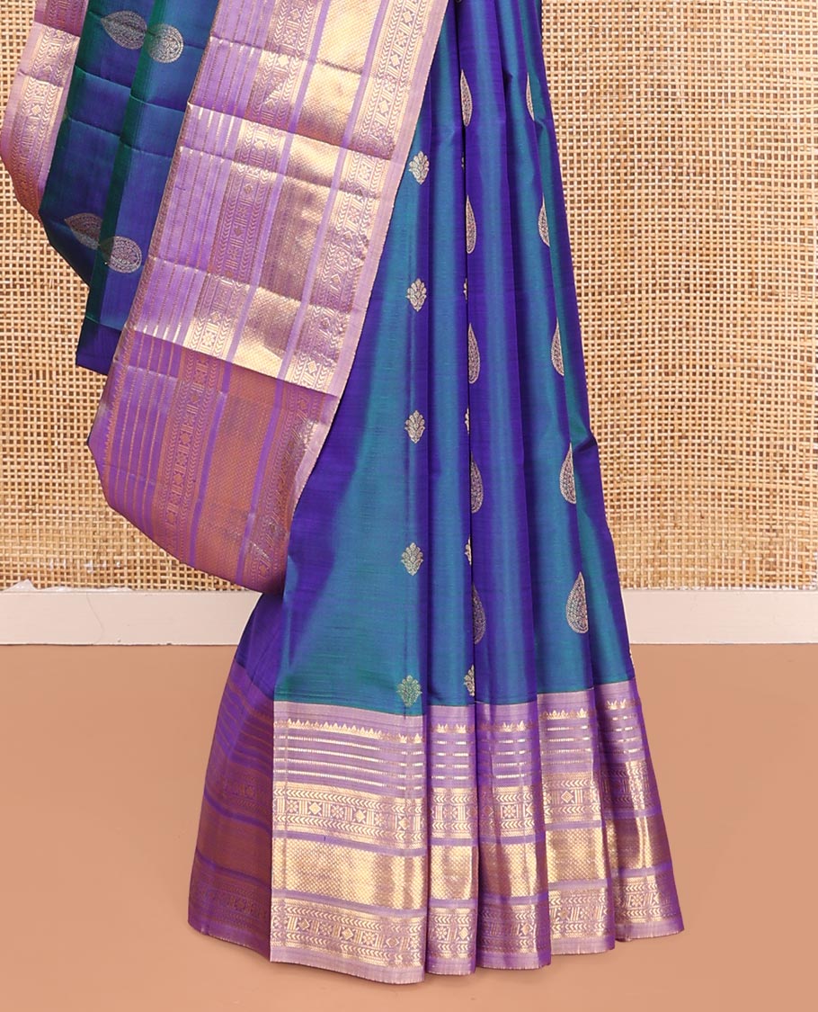 Blue Vasundhara Silk Saree, Adorned with Thilakam and Floral Buttas on Its Body, Complemented by a Contrast Border of Rekku, Muthu, Kathir, Kamalam, Diamond, and Mayil Kann Designs, Pallu Steeped with Intricate Designs, and Paired with a Contrast Blouse