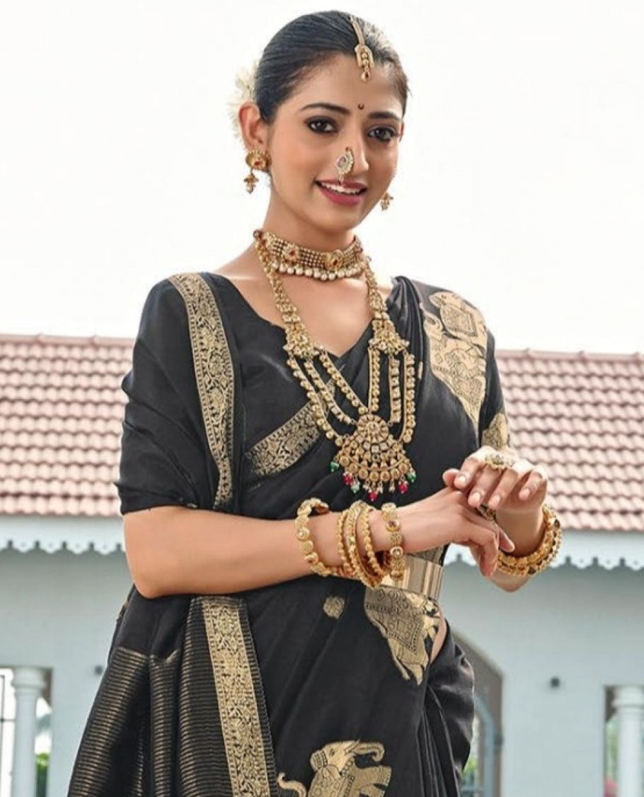 Black Designer Saree, Gracefully Embellished with Zari Buttas, Featuring a Self-Border Depicting a Herd of Elephants, Subtly Woven Pallu of Spare Stripes, and Paired with a Matching Blouse of Elephant Motifs