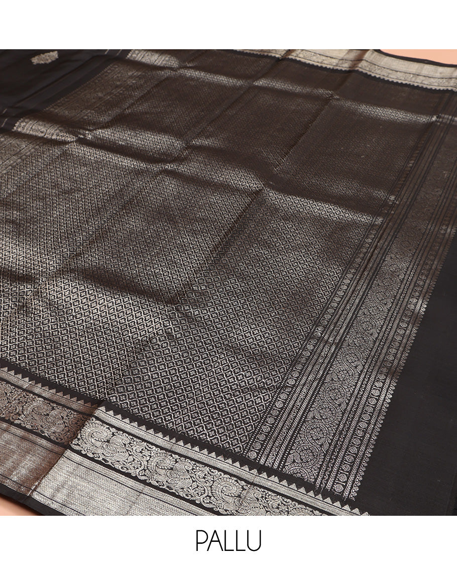 Black Kanchipuram Silk Saree, Dazzled with Zari Buttas All Over Its Body, Highlighted by Zari Border of Rekku, Kathir, Vanki, and Mayil Designs, Pallu of Jaal Design, and Paired with a Matching Blouse